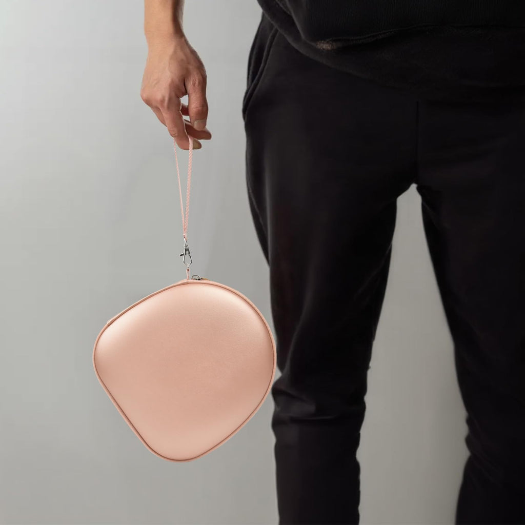 Person carrying the rose gold headphone case by its wrist strap