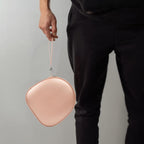 Person carrying the rose gold headphone case by its wrist strap