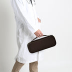 Healthcare professional carrying a closed brown hard stethoscope case