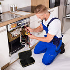 Appliance technician using a multimeter beside the open black and yellow carrying case
