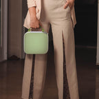 Person carrying the light green NIIMBOT label maker case by its top handle