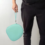 Person carrying the mint green headphone case by its wrist strap