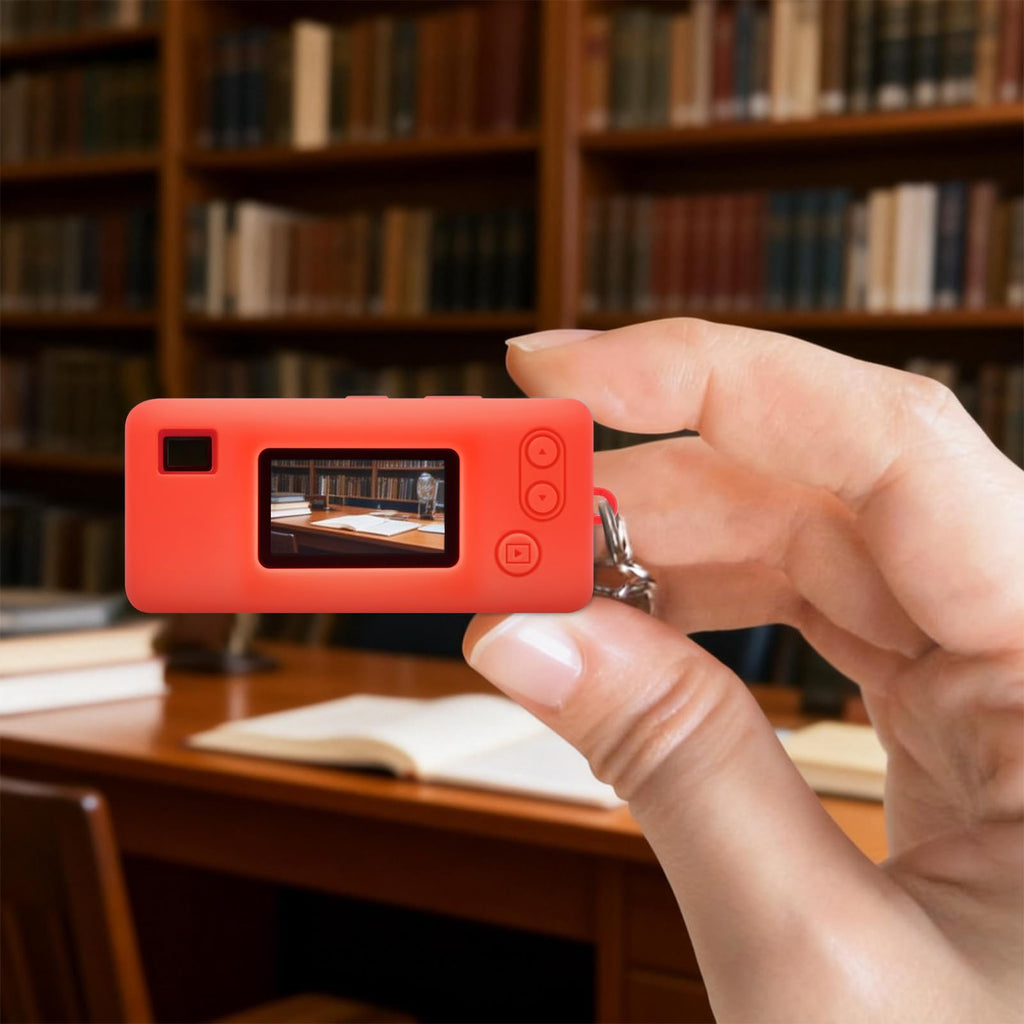 Red silicone case for Kodak Charmera keychain camera shown on the camera while taking a photo indoors