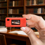 Red silicone case for Kodak Charmera keychain camera shown on the camera while taking a photo indoors