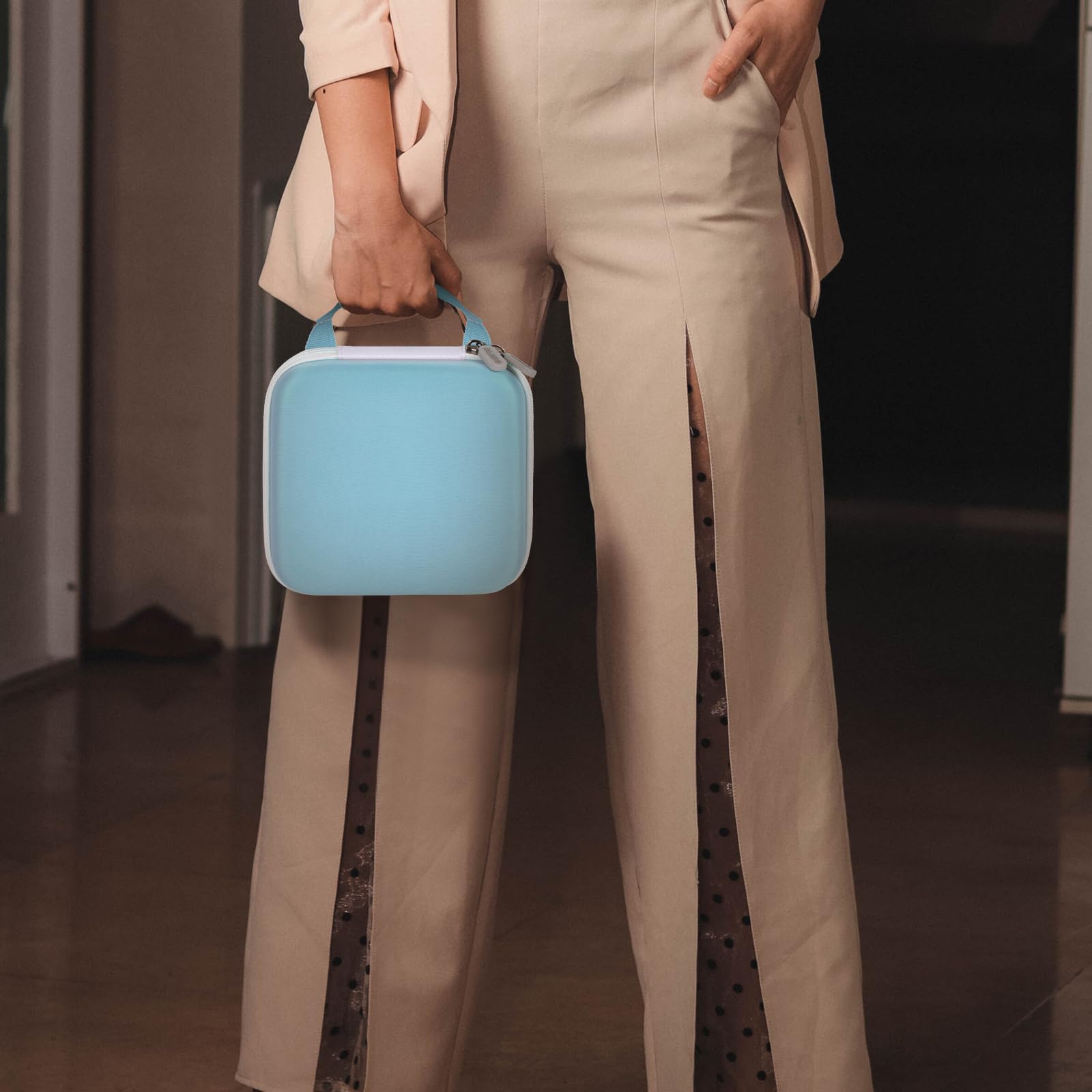 Person carrying the light blue NIIMBOT label maker case by its top handle