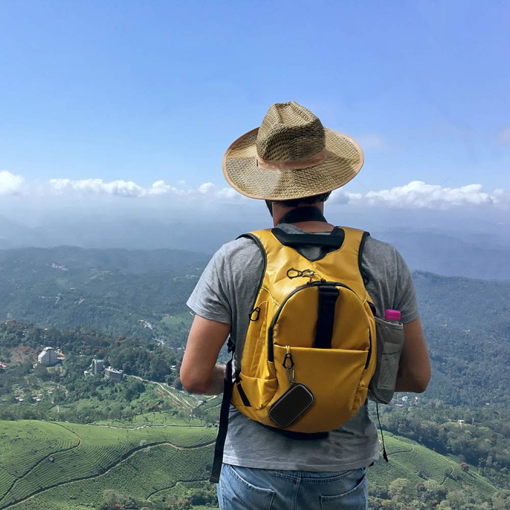 Black music player case clipped to a backpack during a hike