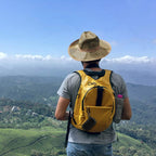 Black music player case clipped to a backpack during a hike