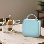 Closed light blue NIIMBOT label maker case beside bottles and jars