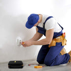 Electrician using test equipment beside the closed black and yellow multimeter case