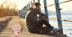 Traveler resting beside luggage and the open pink headphone case