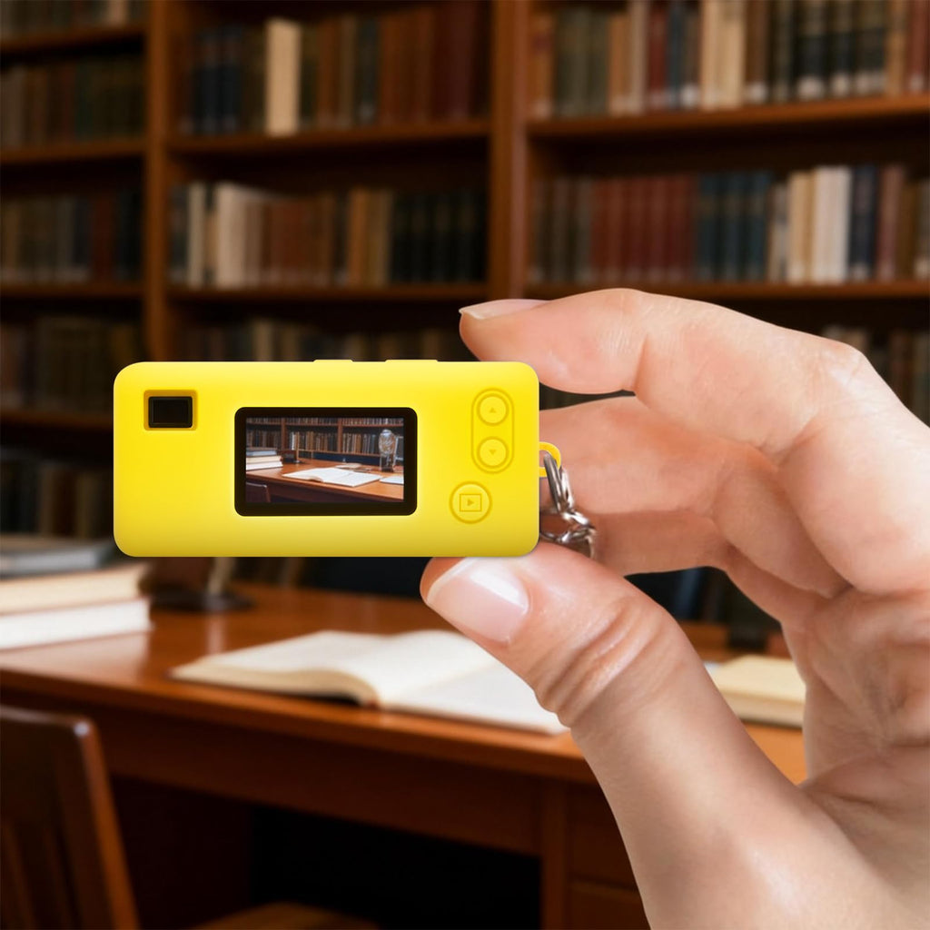 Yellow with retro camera graphic silicone case for Kodak Charmera keychain camera shown on the camera while taking a photo indoors