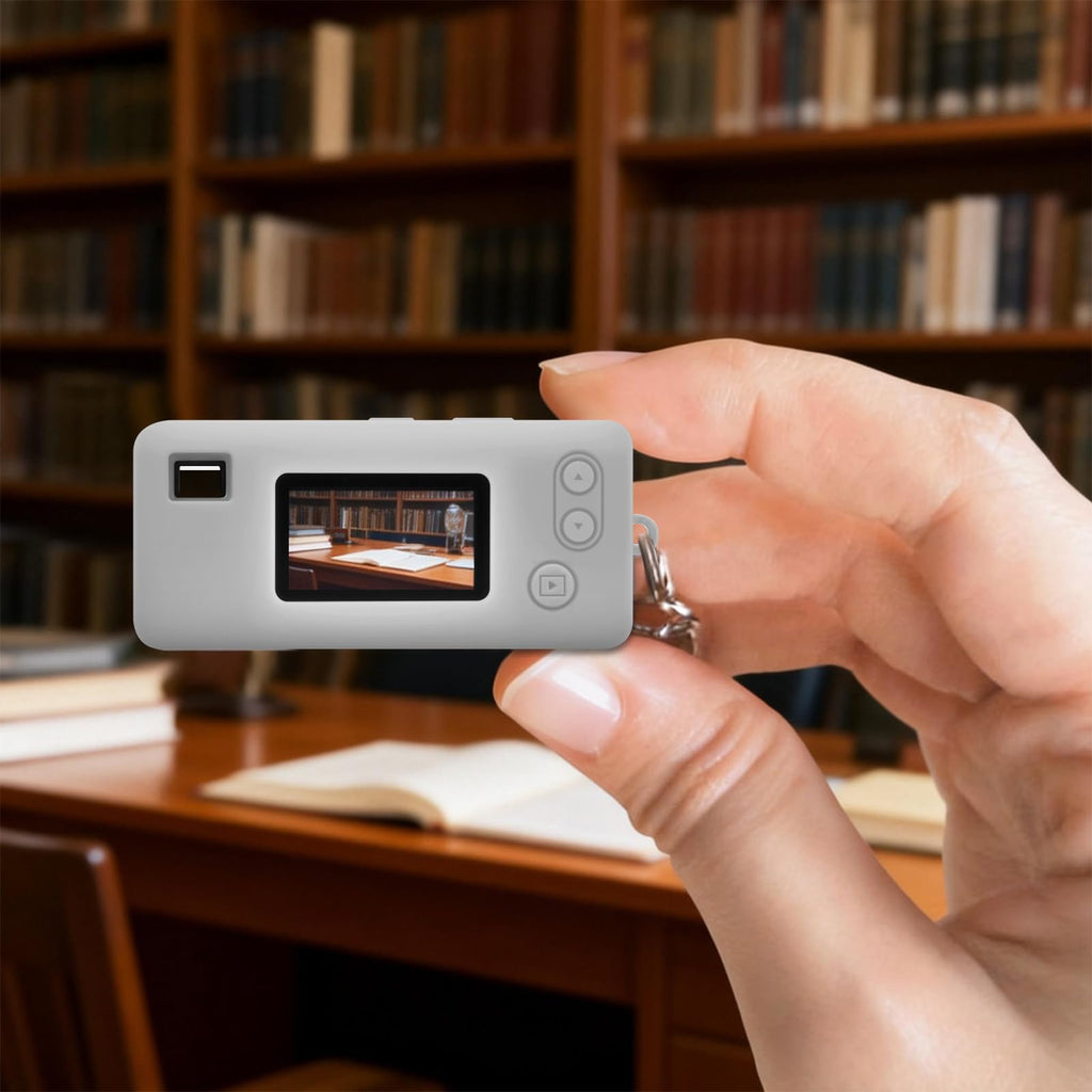 Gray silicone case for Kodak Charmera keychain camera shown on the camera while taking a photo indoors