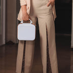 Person carrying the white and tan NIIMBOT label maker case by its top handle