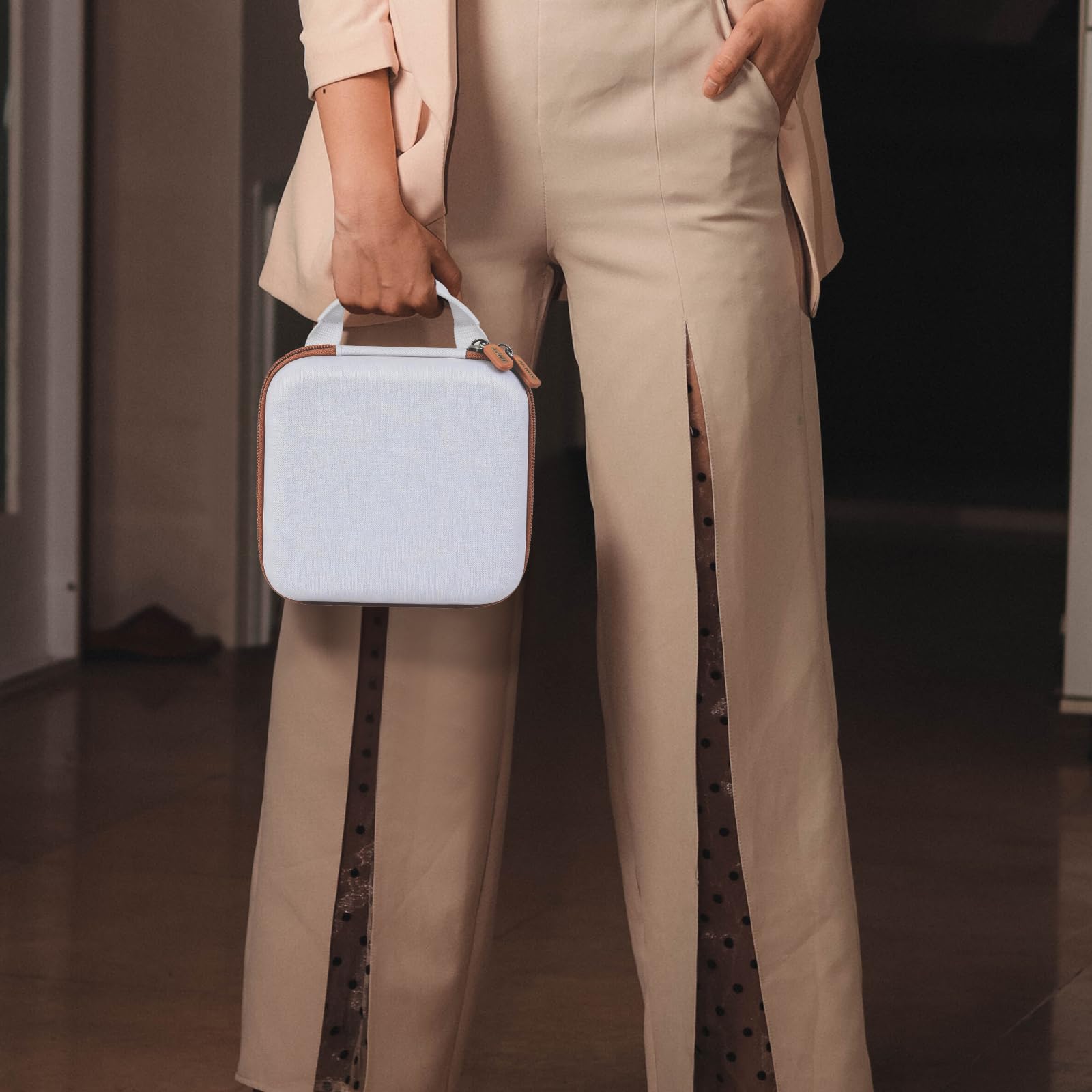 Person carrying the white and tan NIIMBOT label maker case by its top handle