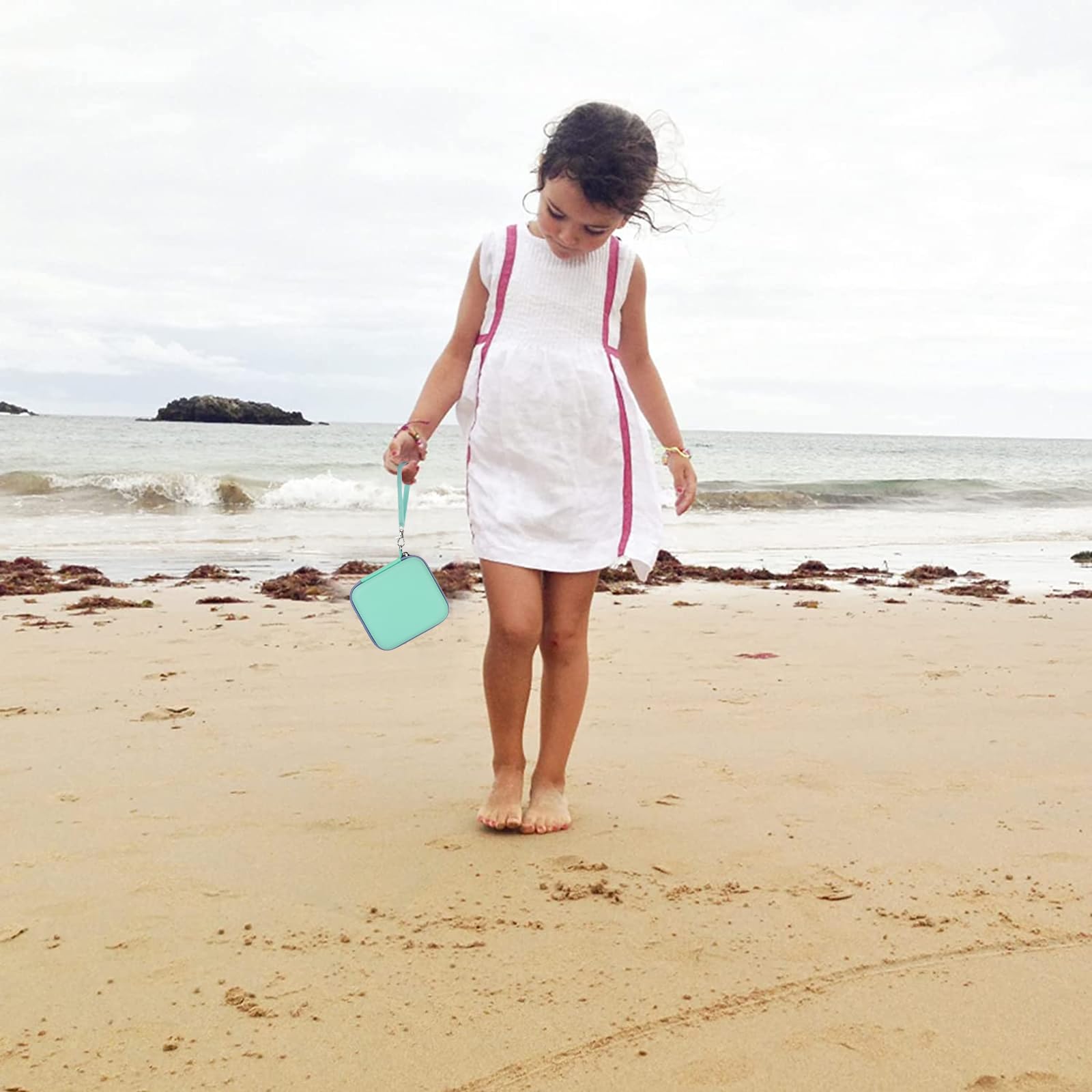 Mint green kids instant print camera case open beside a child using the camera with a parent