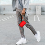 Person carrying the red charging station case by its wrist strap