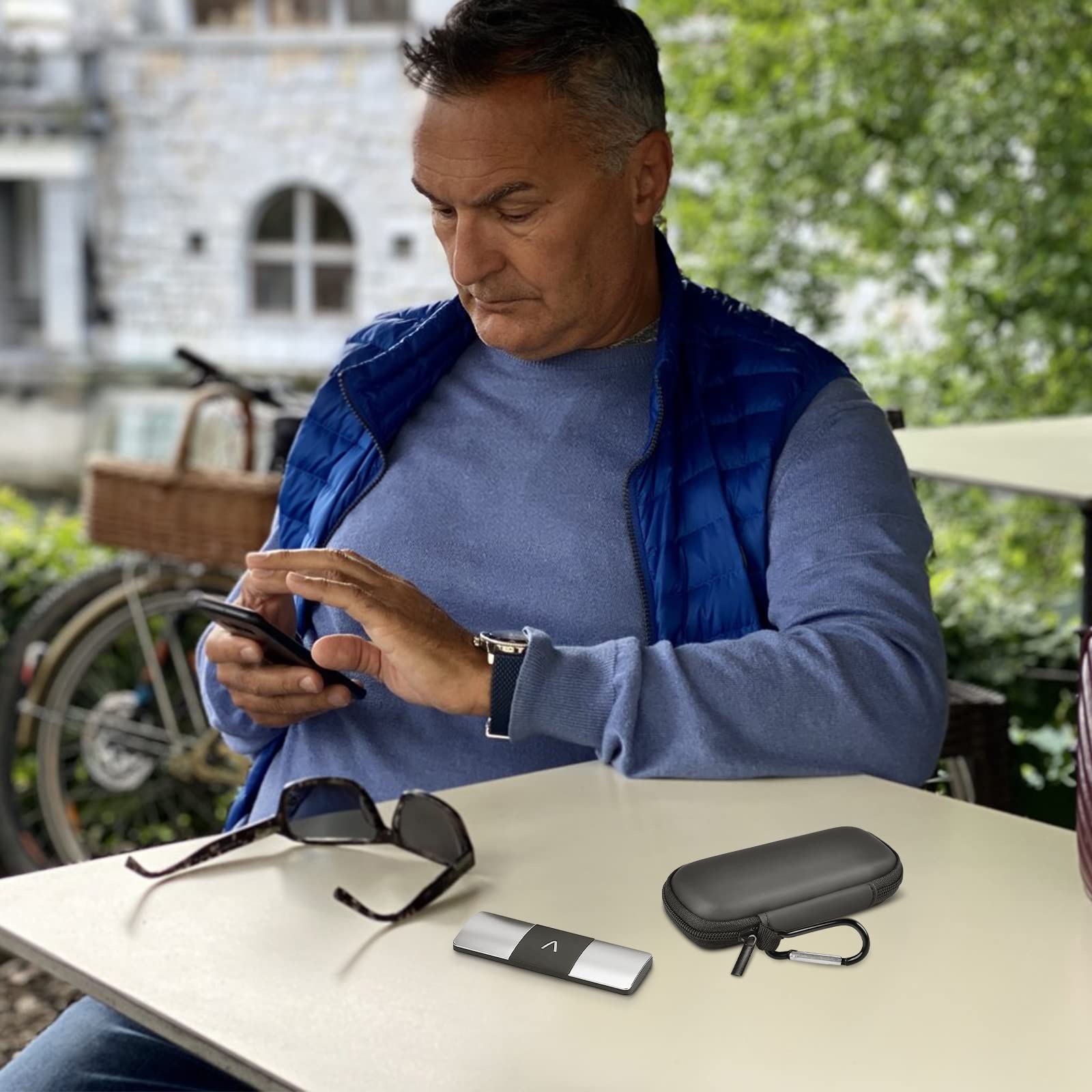 Man using a KardiaMobile device beside the open black travel case