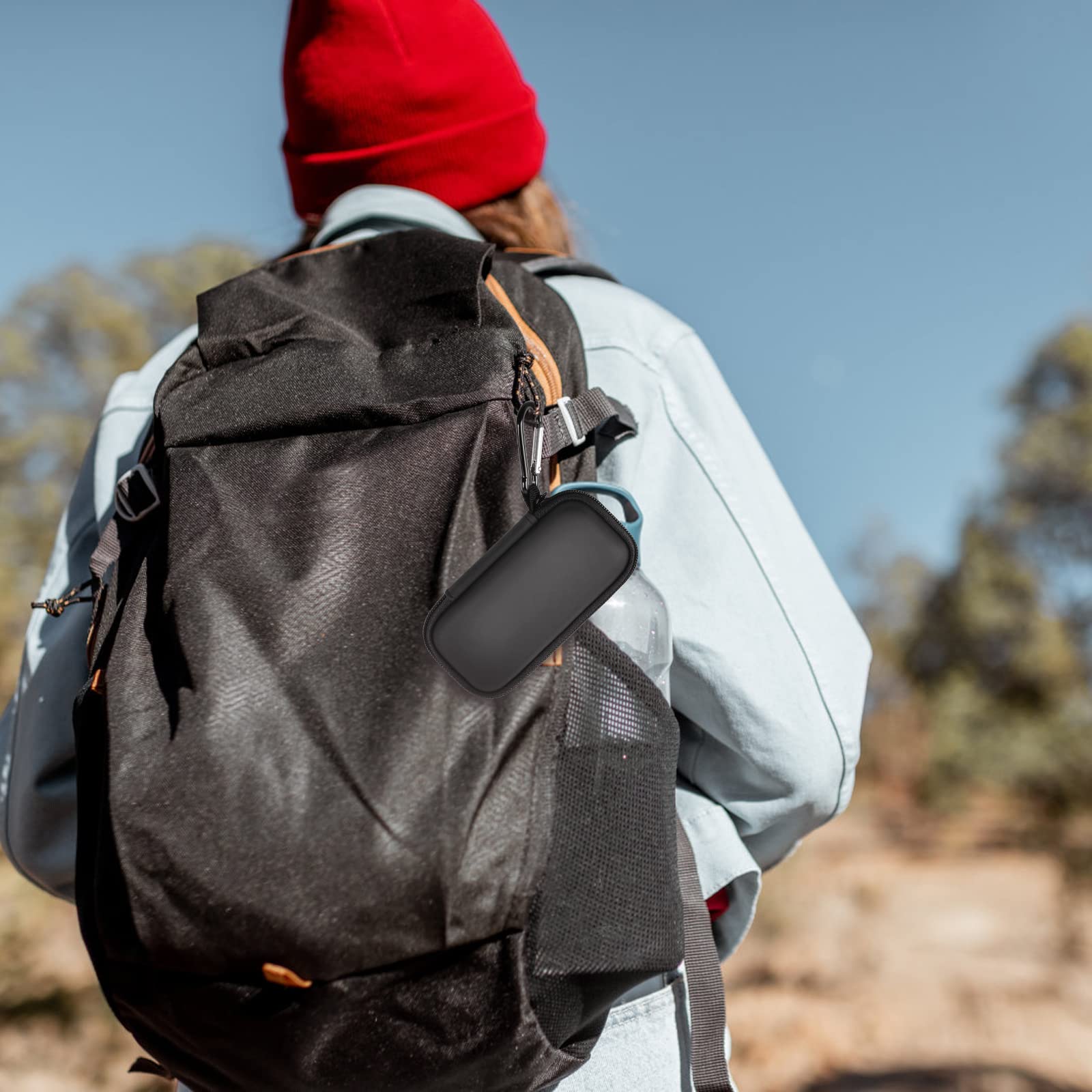 Black KardiaMobile case clipped to a hiking backpack