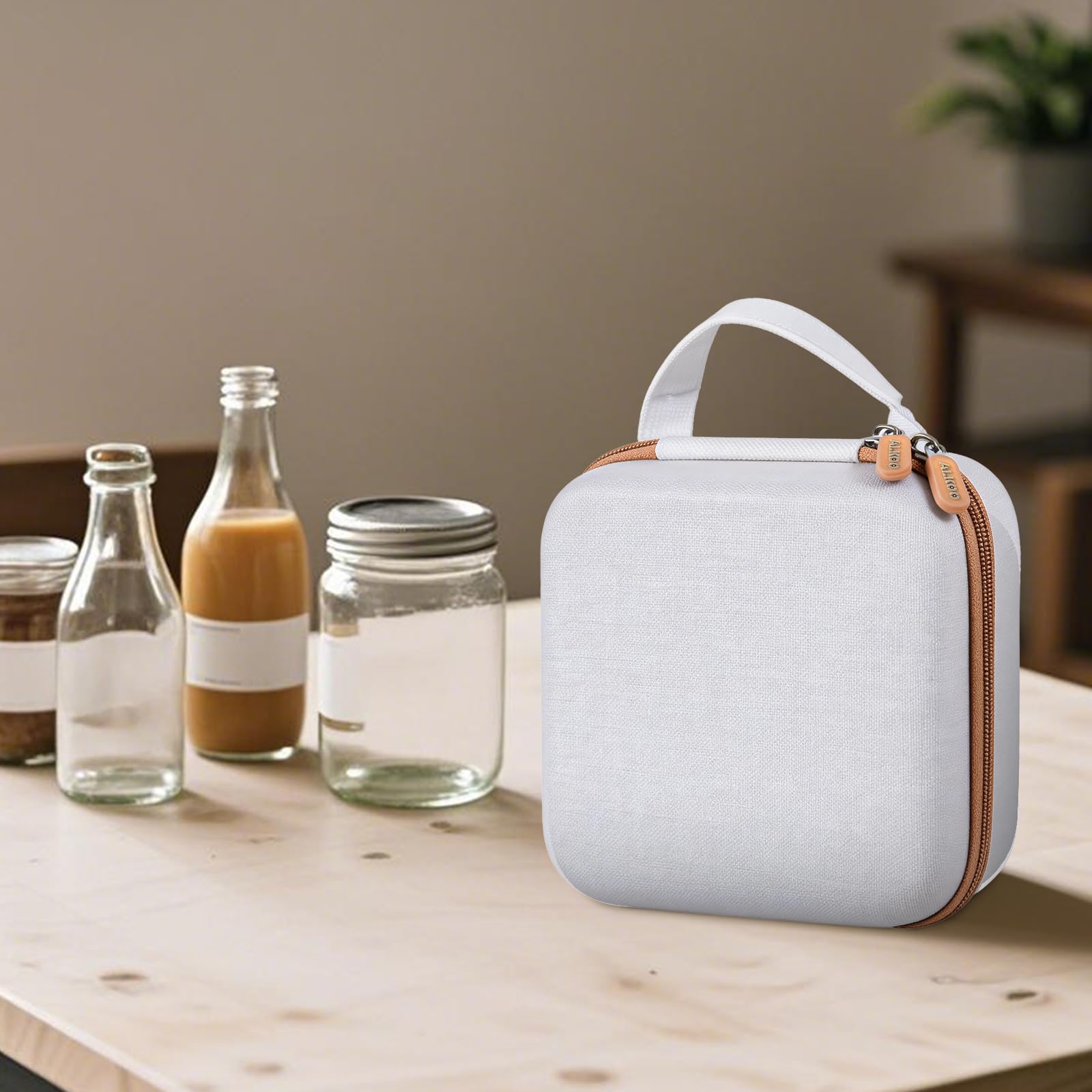 Closed white and tan NIIMBOT label maker case beside bottles and jars