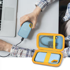 Open blue and yellow SSD organizer beside a SanDisk drive connected to a laptop