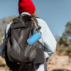 Blue KardiaMobile case clipped to a hiking backpack