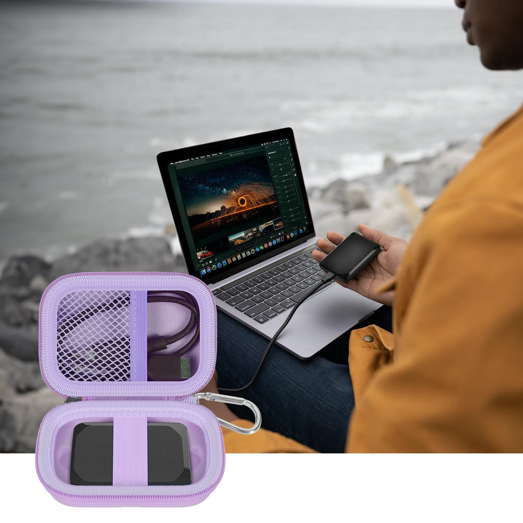 Open lavender SSD organizer beside a Crucial portable drive connected to a laptop