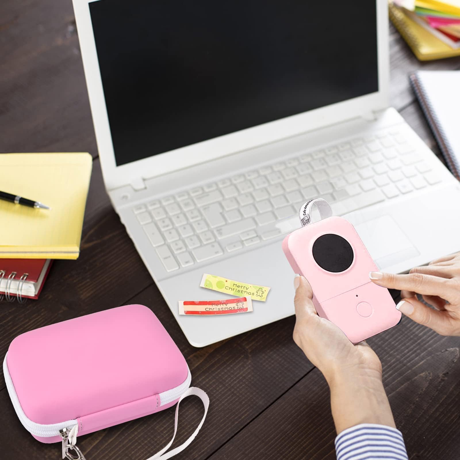 Pink mini printer case beside a laptop during label-making work
