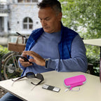 Man using a KardiaMobile device beside the open pink travel case