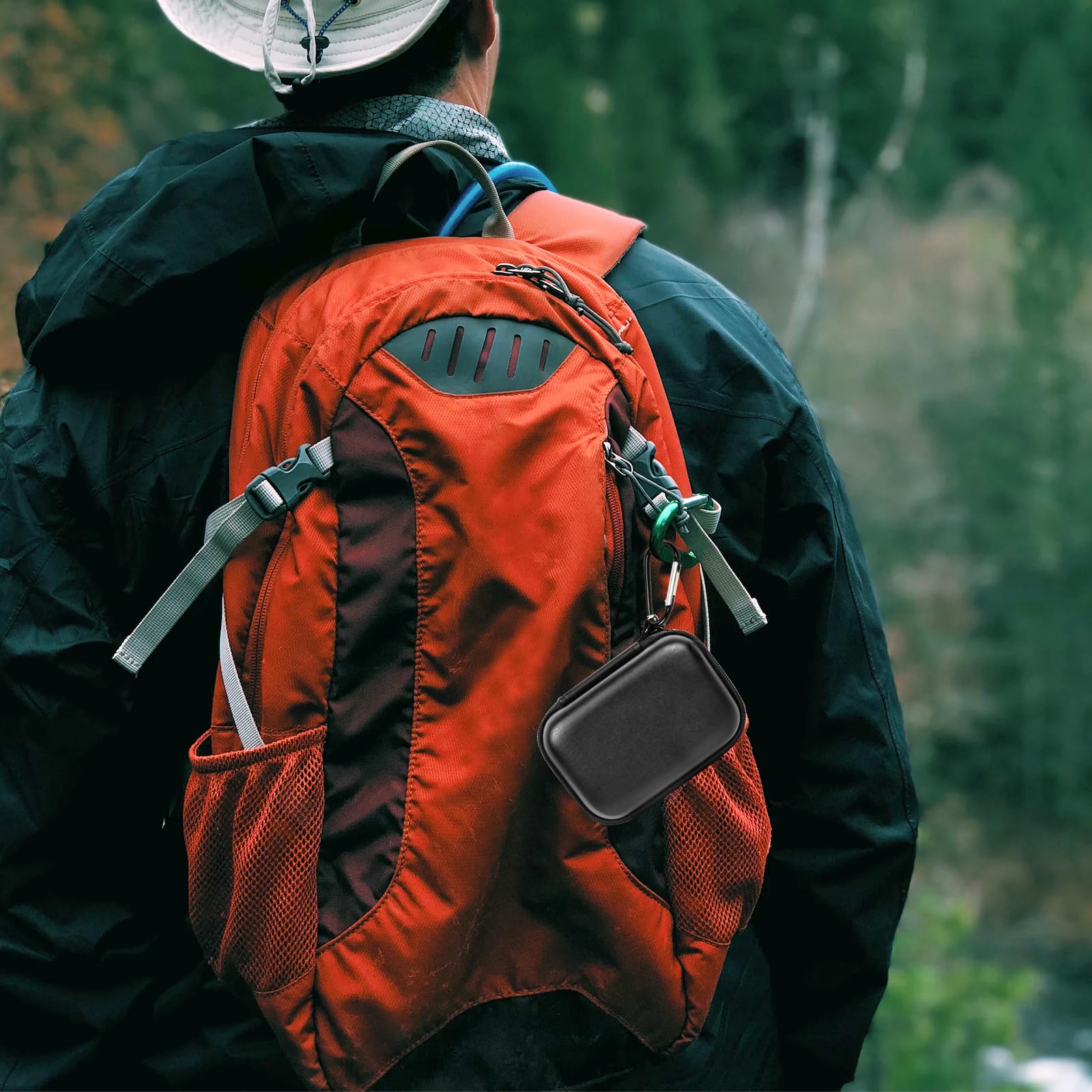 Black Crucial SSD case clipped to a hiking backpack