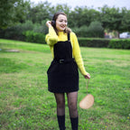 Woman carrying the beige headphone case by its wrist strap