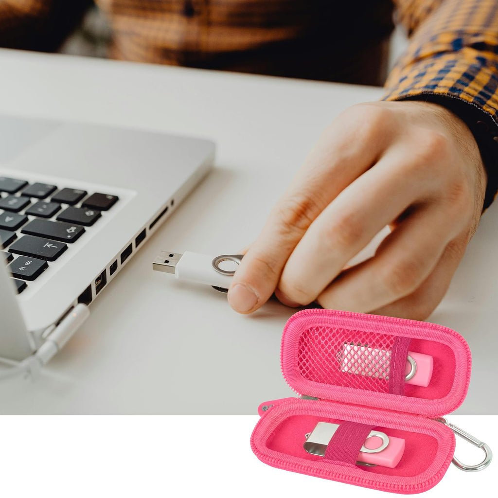 Hot pink USB flash drive and SD card storage case open beside a laptop during use