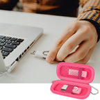 Hot pink USB flash drive and SD card storage case open beside a laptop during use