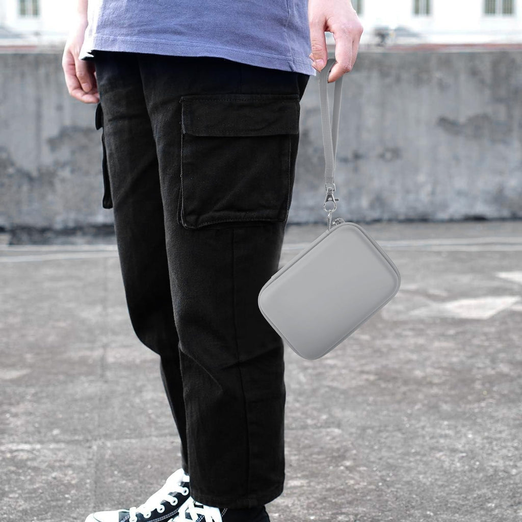Gray retro handheld console carrying case carried by the wrist strap outdoors
