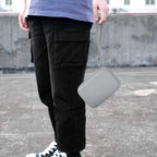 Gray retro handheld console carrying case carried by the wrist strap outdoors
