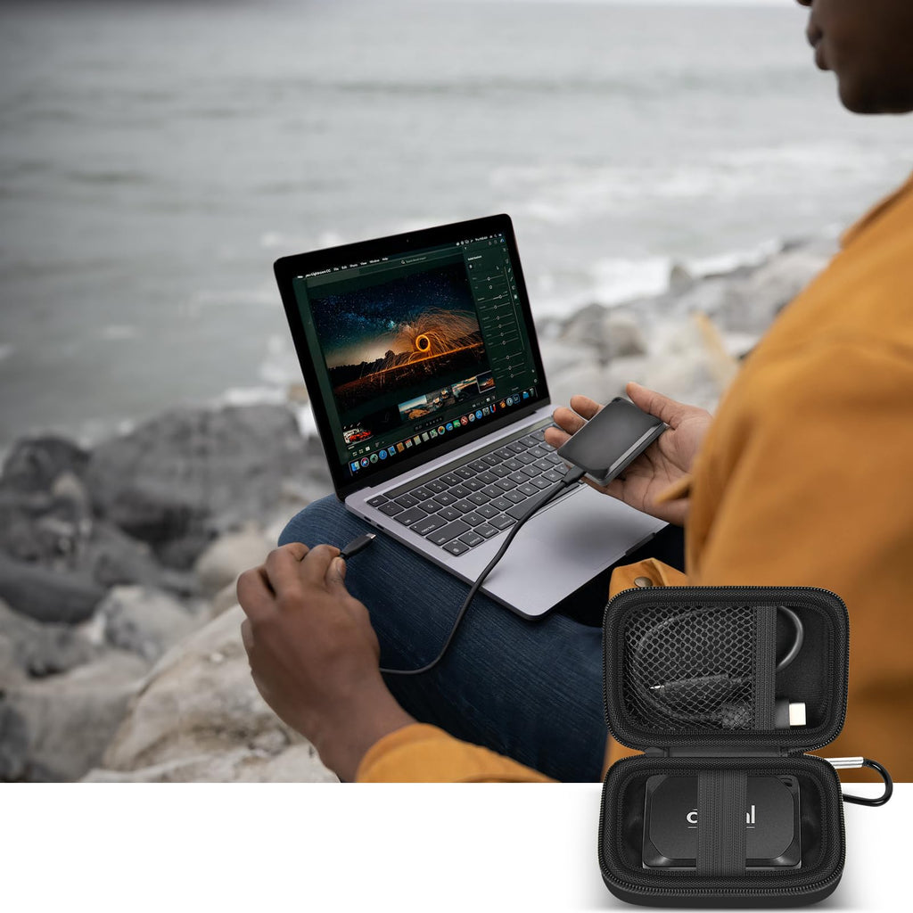 Open black SSD organizer beside a Crucial portable drive connected to a laptop