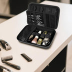 Open black clipper case organizing clippers, bottles, scissors, combs, and guards on a counter