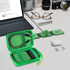 Open green case organizing a foldable magnetic charger, cable, and adapter on a desk