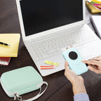 Mint green mini printer case beside a laptop during label-making work