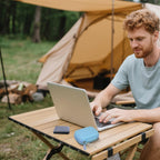 Light blue SSD case beside a portable drive during outdoor laptop use