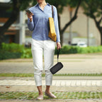 Person carrying the black power bank case by its wrist strap