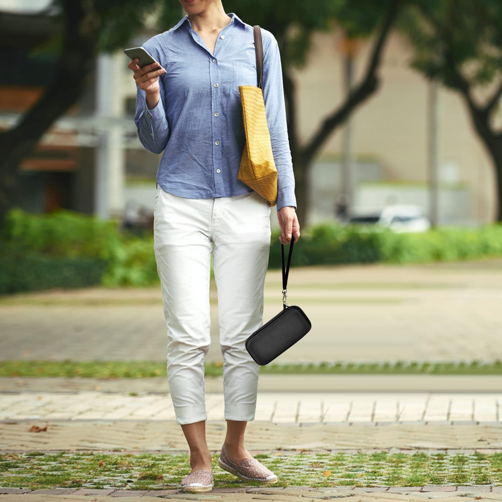 Person carrying the black power bank case by its wrist strap