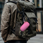 Light pink USB flash drive and SD card storage case clipped to a backpack