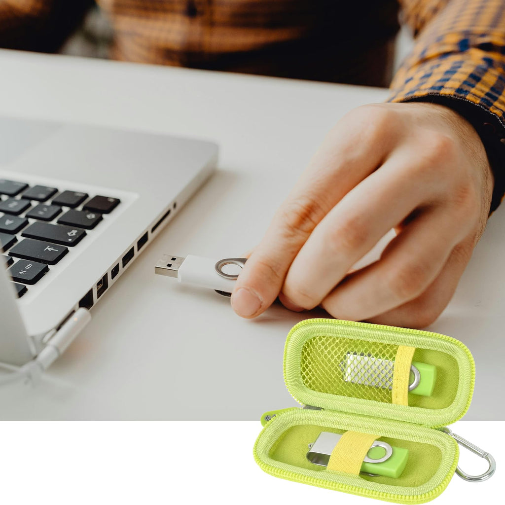 Neon green USB flash drive and SD card storage case open beside a laptop during use