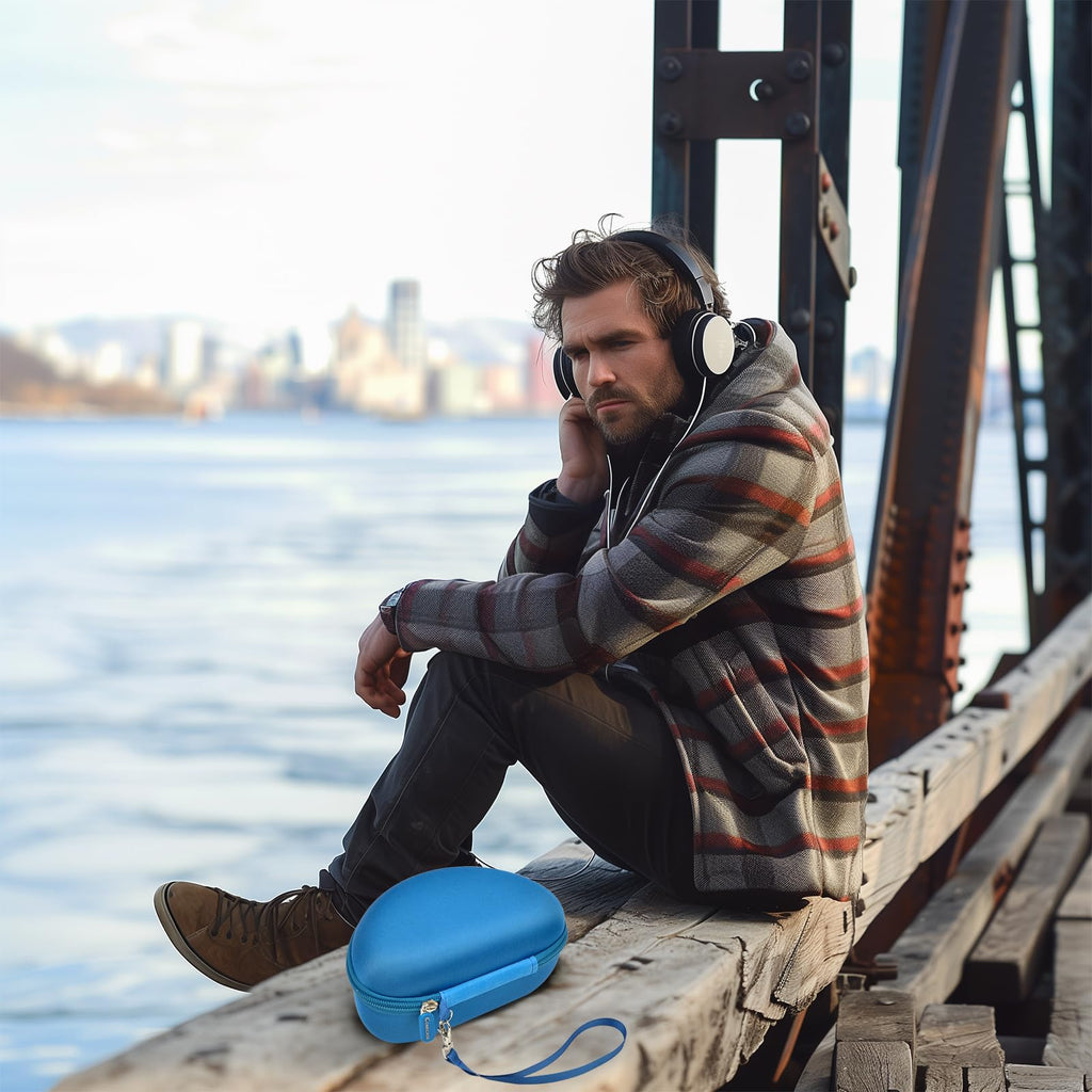 Man resting at a waterfront beside the open blue headphone case