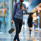 Traveler carrying the black power bank case by its wrist strap