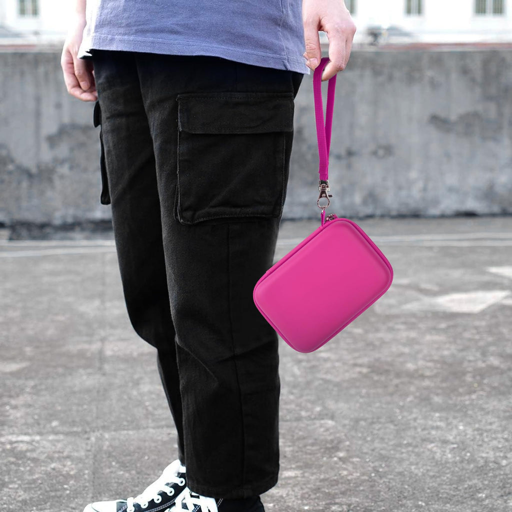 Pink retro handheld console carrying case carried by the wrist strap outdoors