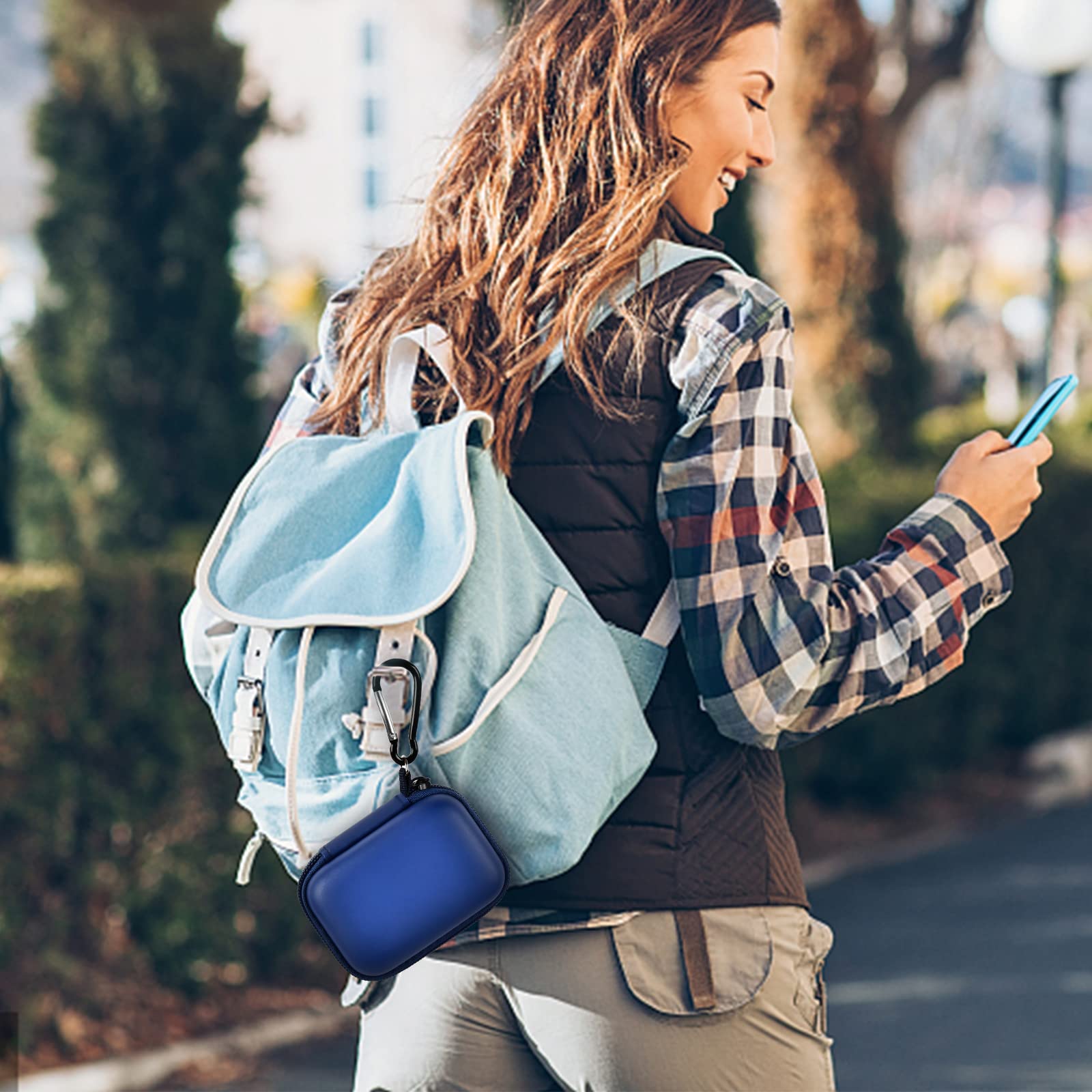 Navy blue mini power bank case attached to a backpack for travel