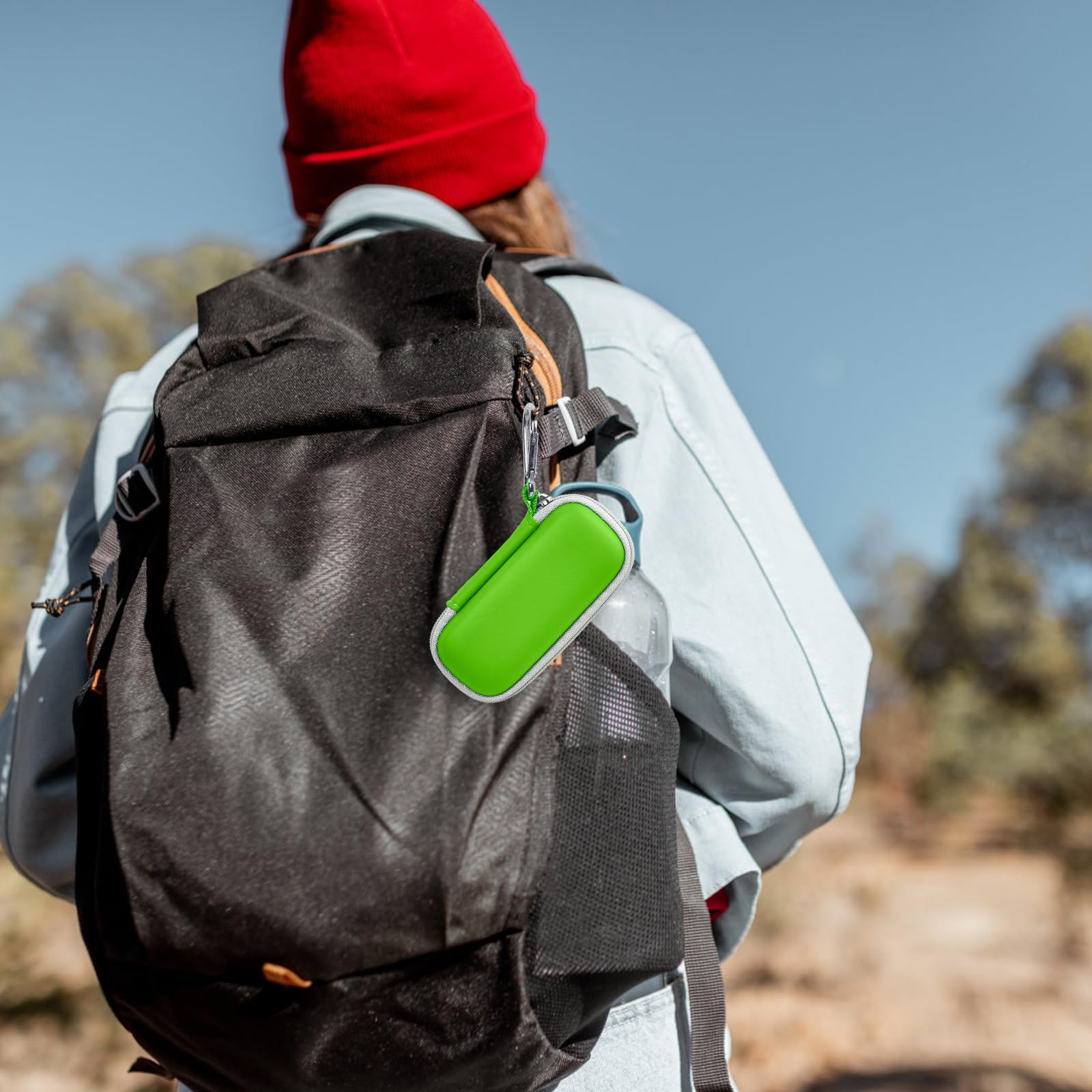 Green KardiaMobile case clipped to a hiking backpack