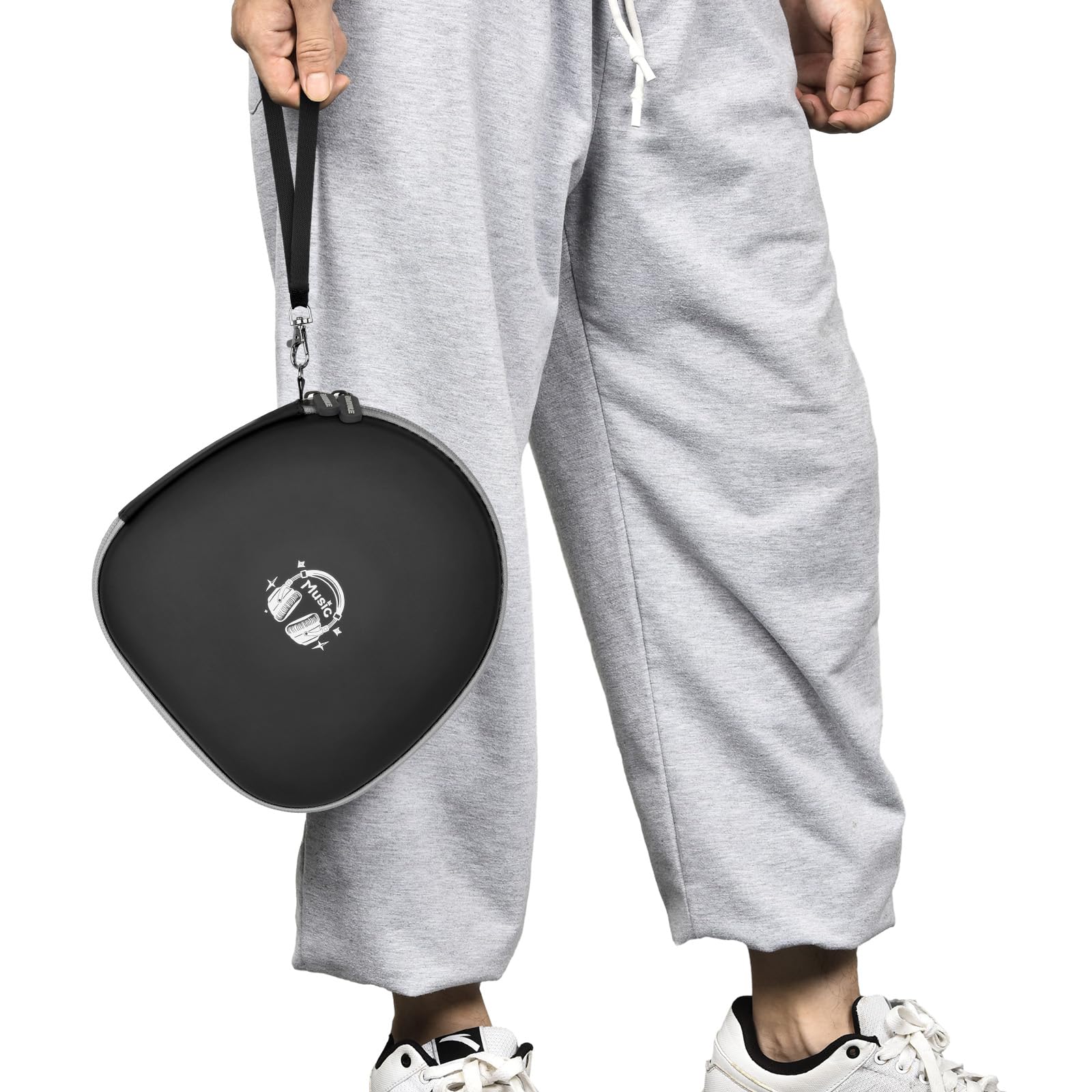 Person carrying the black headphone case by its wrist strap
