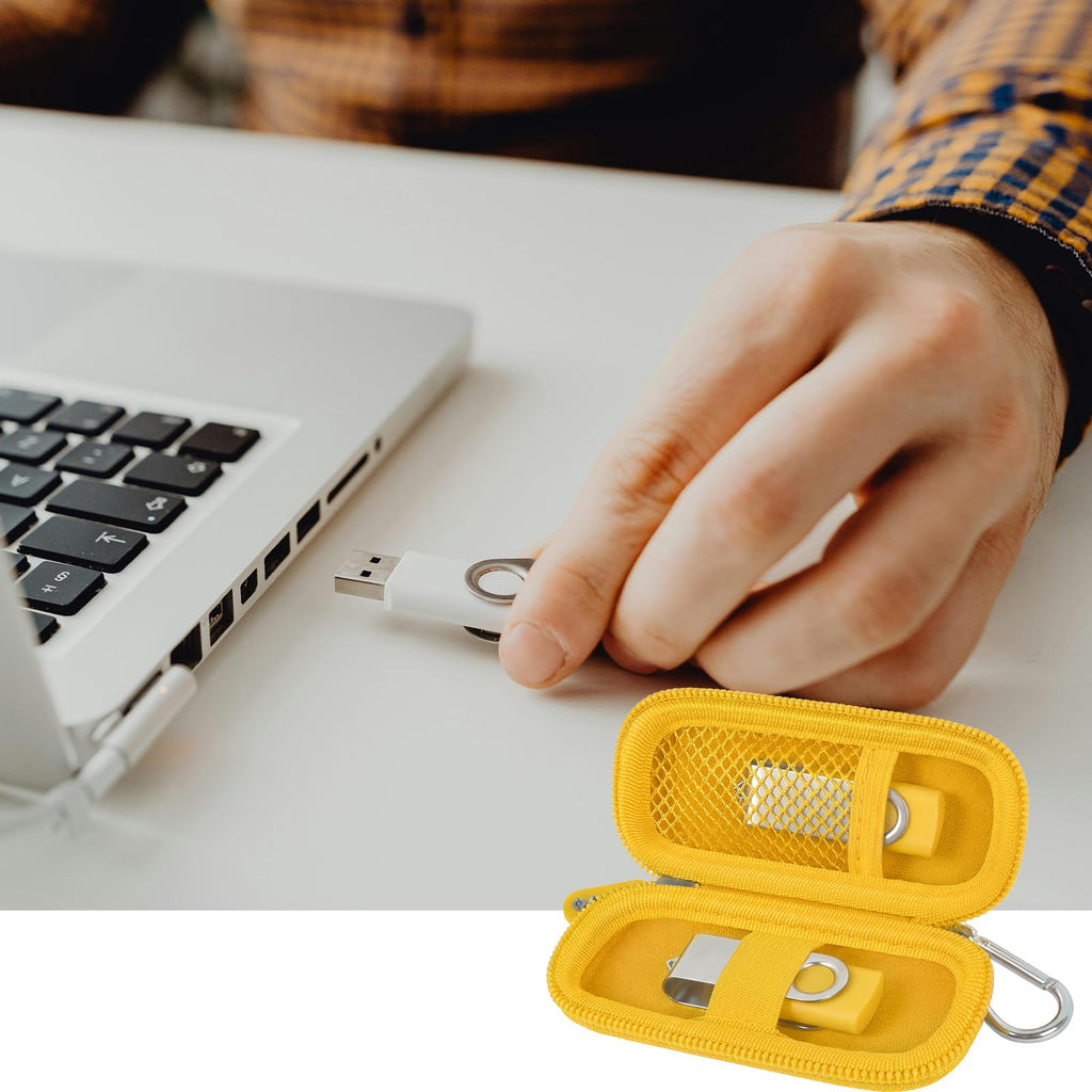 Yellow USB flash drive and SD card storage case open beside a laptop during use